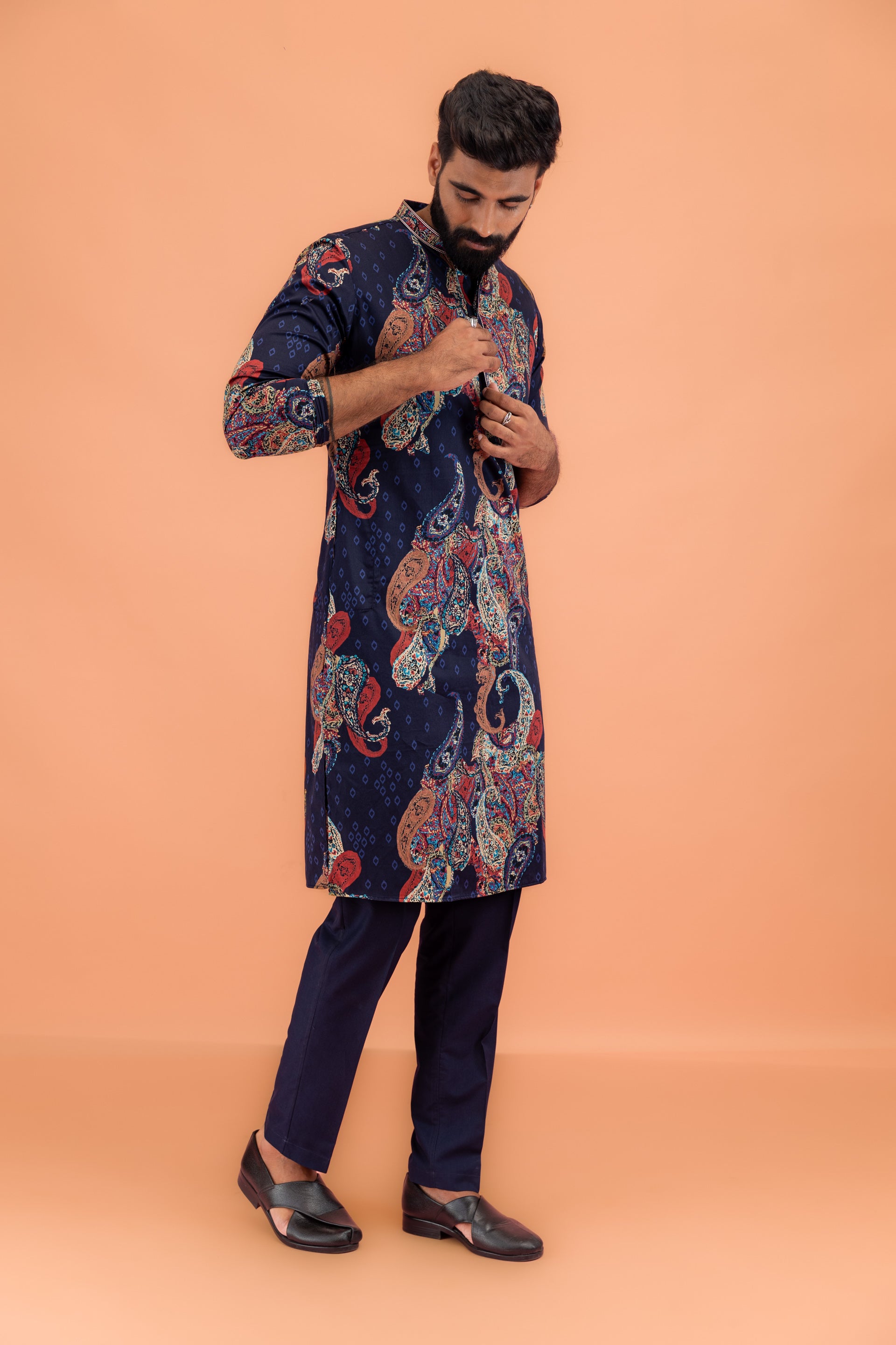 The model is standing in a pose trying to adjust his buttons on kurta set by Kisah