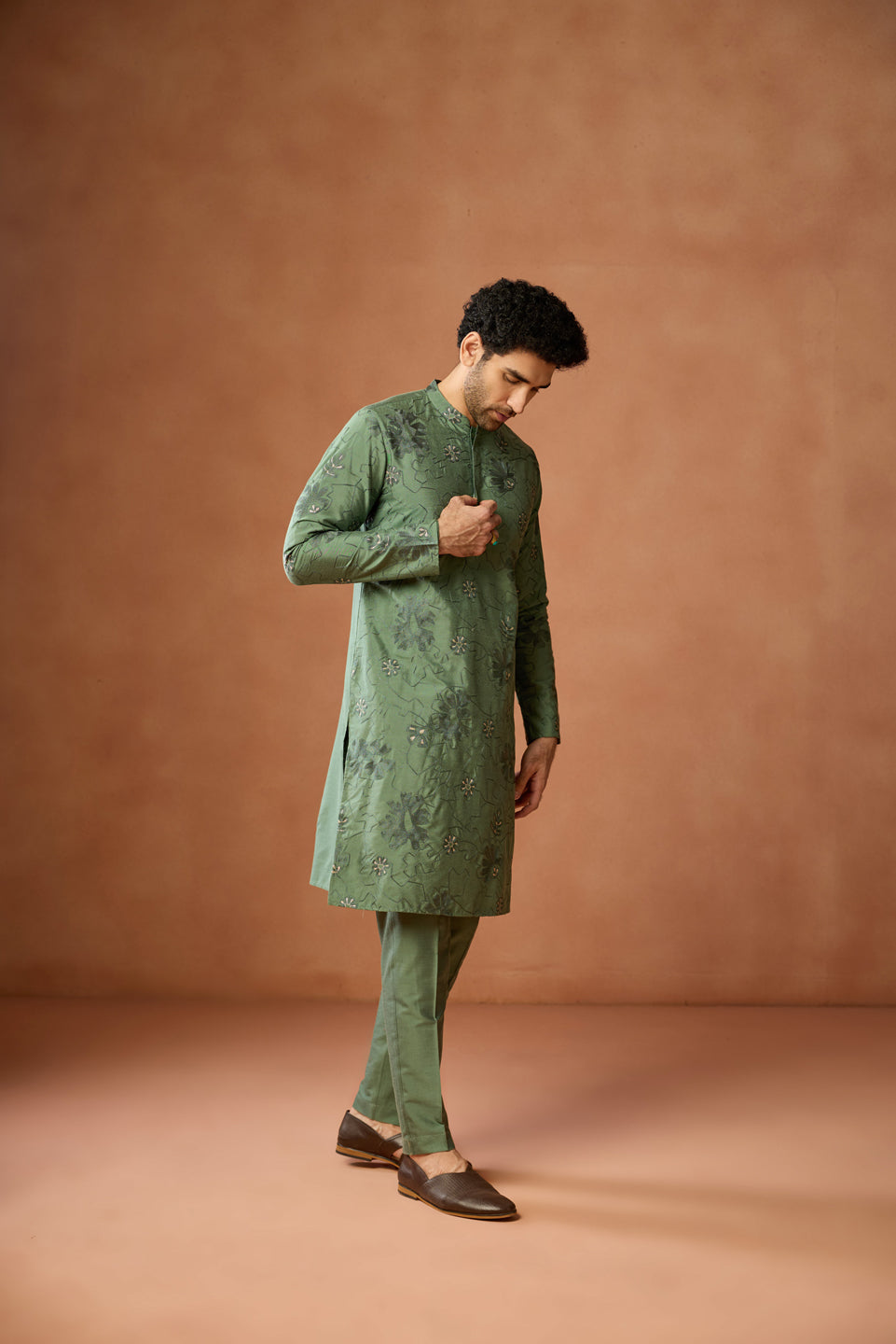 Wearing Kisah's Green Floral Embroidered Kurta Set, the model stands with his head lowered