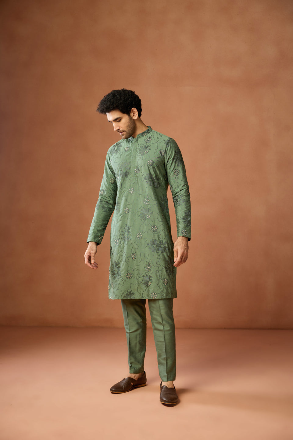 The model, dressed in Green Floral Embroidered Kurta Set, looks down gracefully
