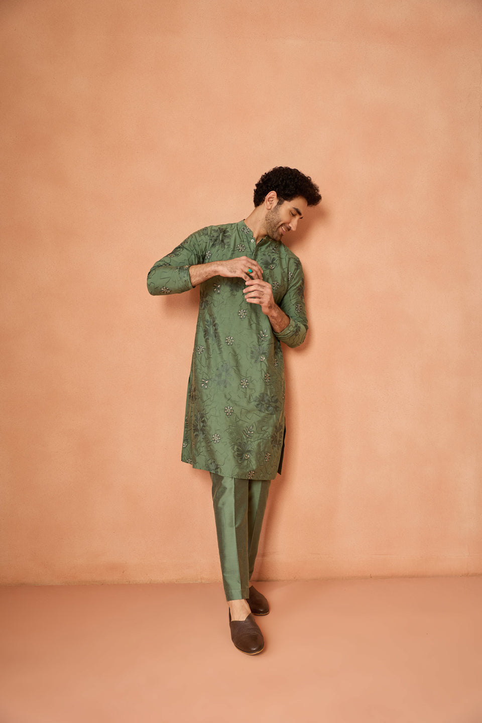 Dressed in Kisah’s Green Floral Embroidered Kurta Set, the man strikes a pose