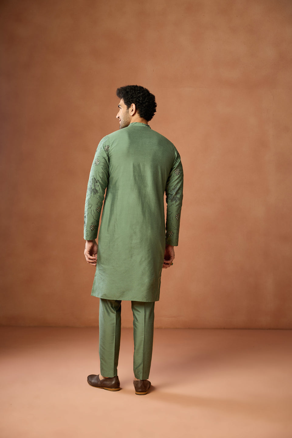 The backside of the model is highlighted, wearing Kisah's  Green Floral Embroidered Kurta Set