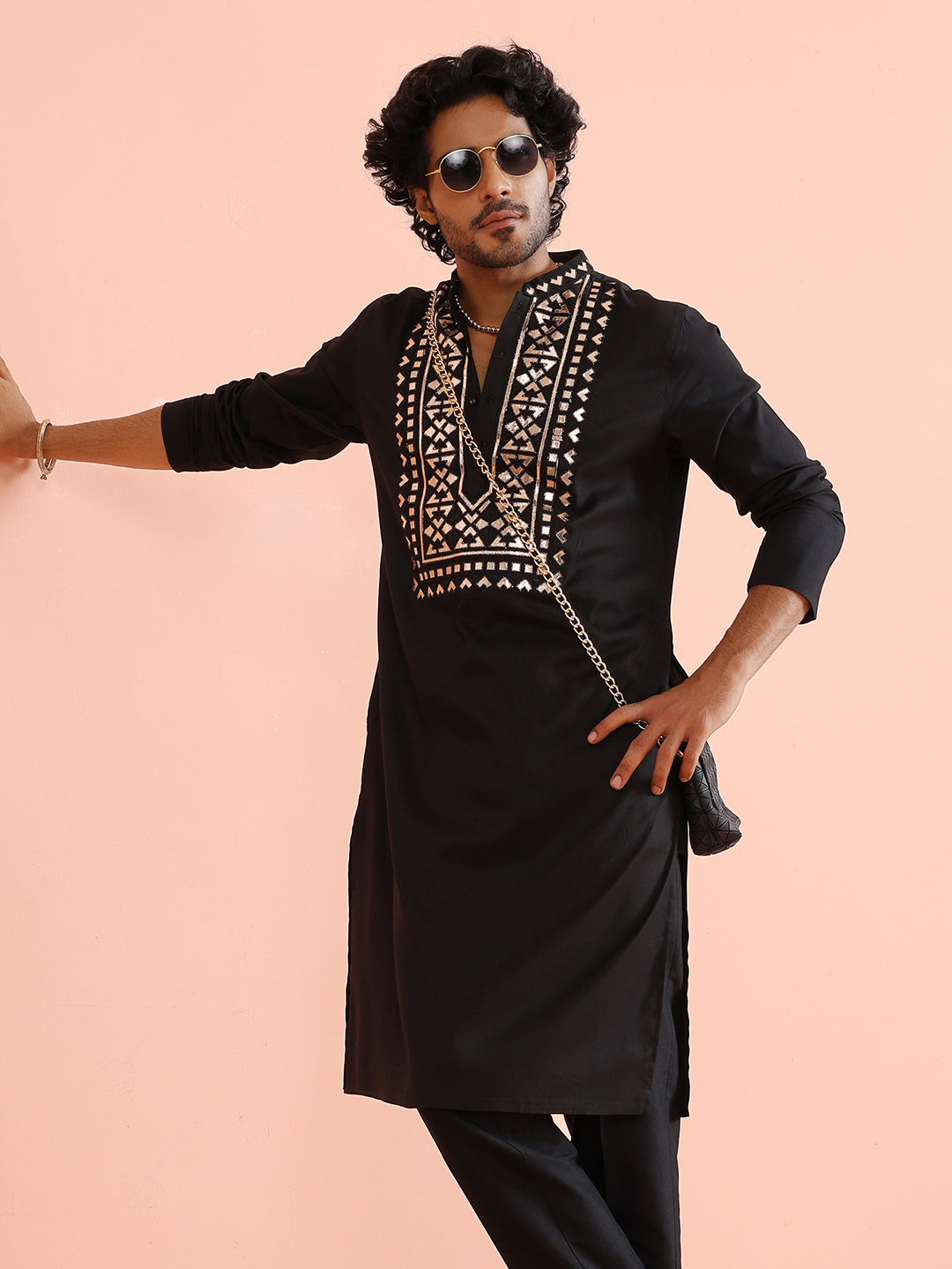 The model strikes a stylish pose in Kisah's Black Metallic Embroidered Kurta Set, with his hand on his waist